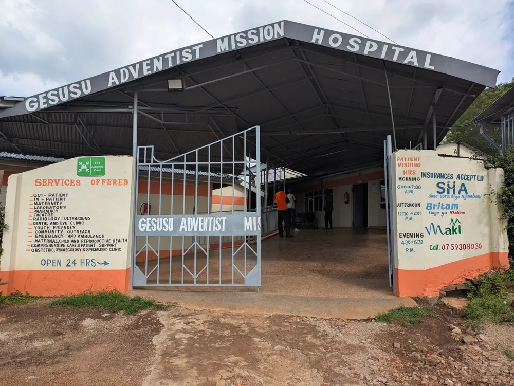The entrance to Gesusu Adventist Mission Hospital, with its services and visiting hours displayed beside the gate